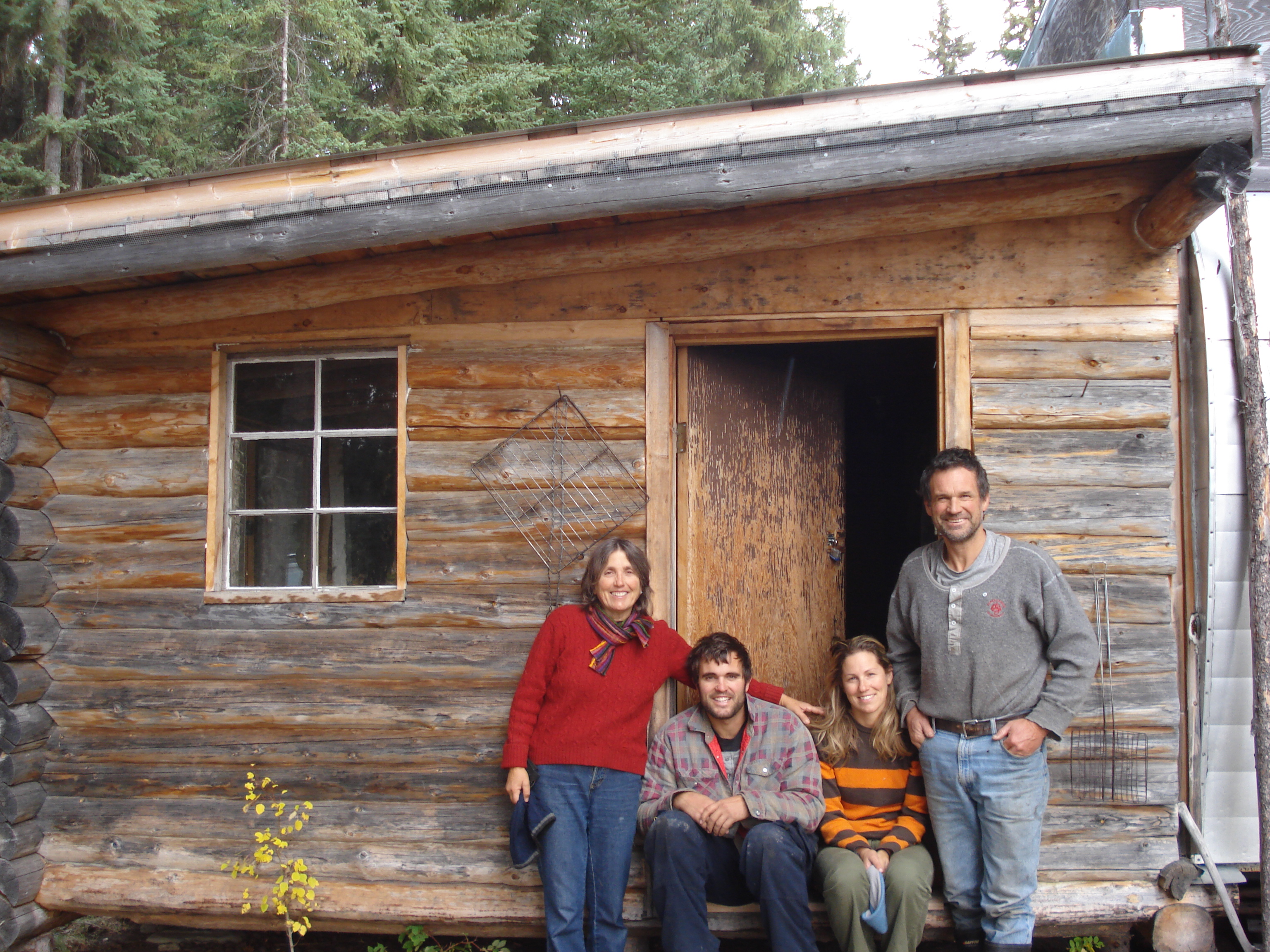 Family in front of wood cabin